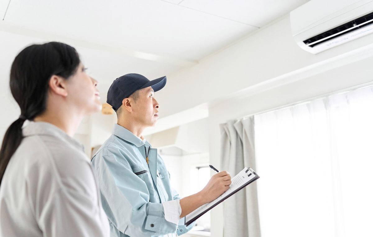 Técnico refrigerista explicando o dimensionamento dos BTUs na instalação de ar-condicionado para o cliente