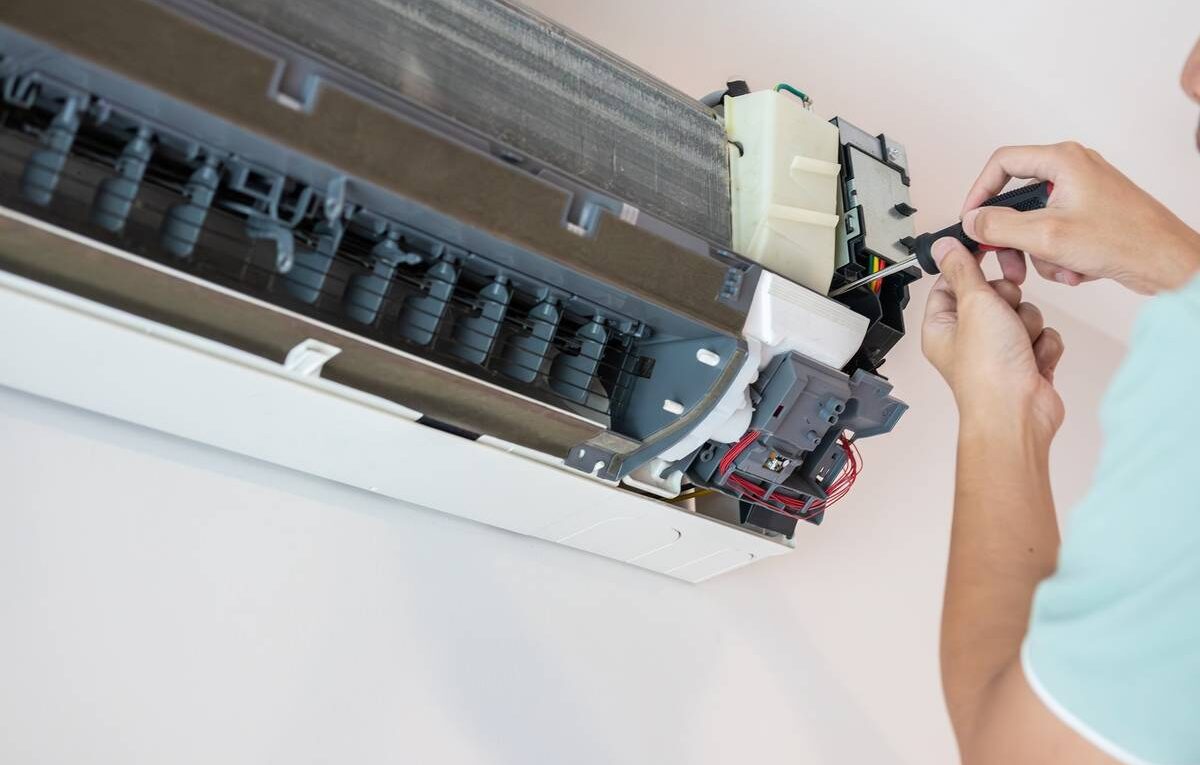 Técnico refrigerista consultando código de erro em split inverter no display do aparelho