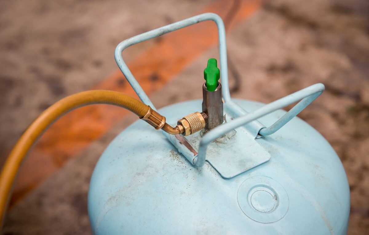 Botija de gás refrigerante com mangueira de serviço conectada para carga de refrigerante por peso