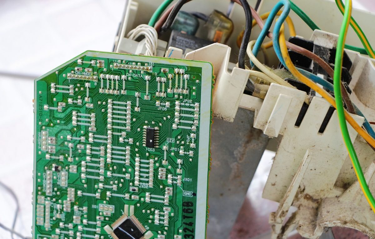 Placa eletrônica de ar-condicionado inverter removida da unidade com fiação exposta ao lado
