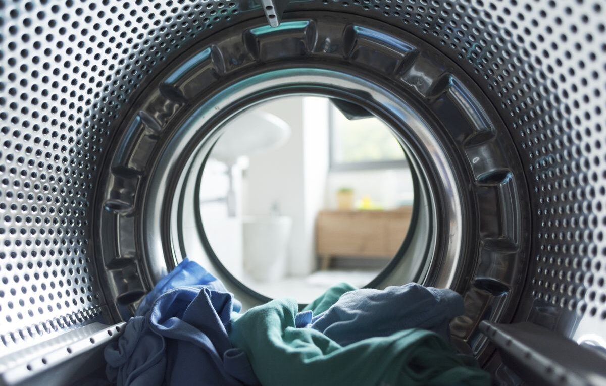 Vista interna do tambor de uma máquina de lavar com roupas, ilustrando diagnóstico de falha na centrifugação
