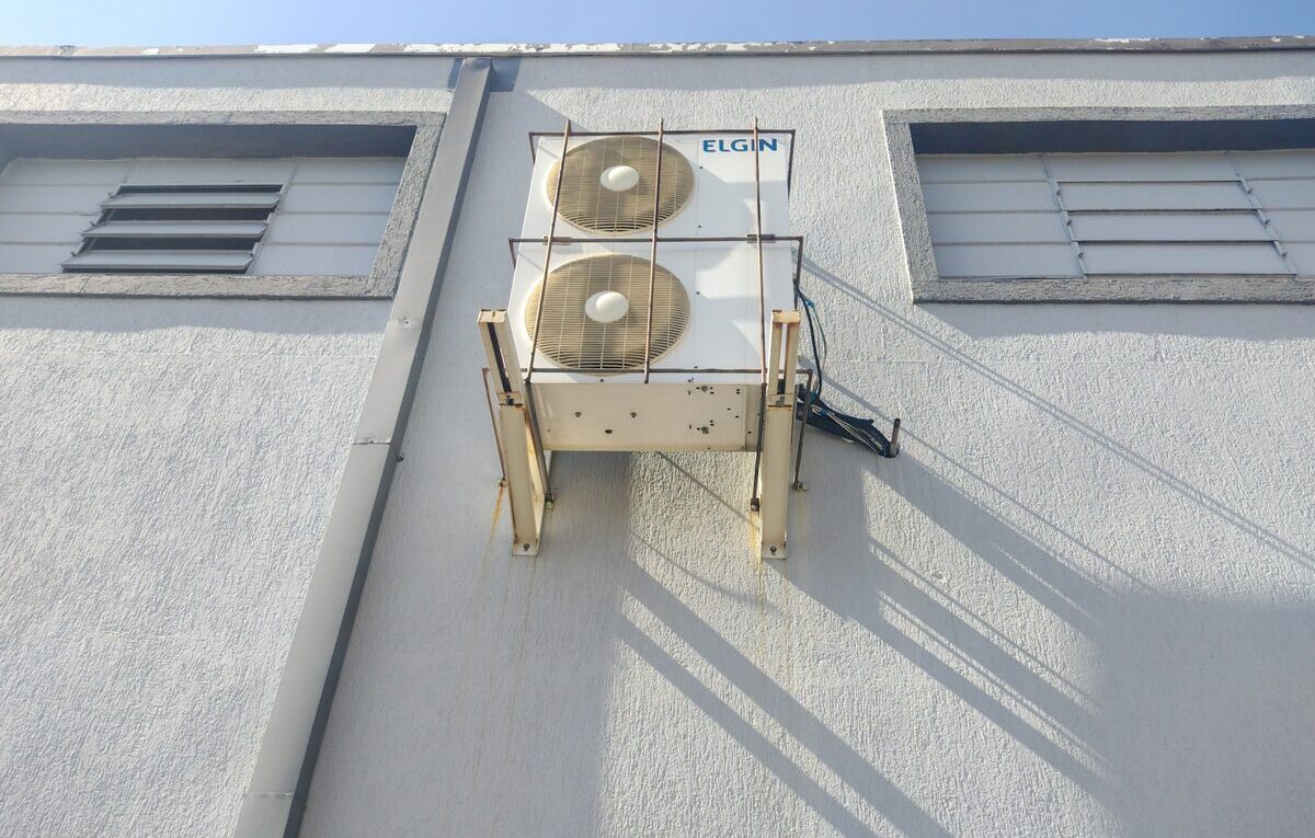 Condensadora de ar-condicionado Elgin com dois ventiladores instalada na fachada de um prédio.